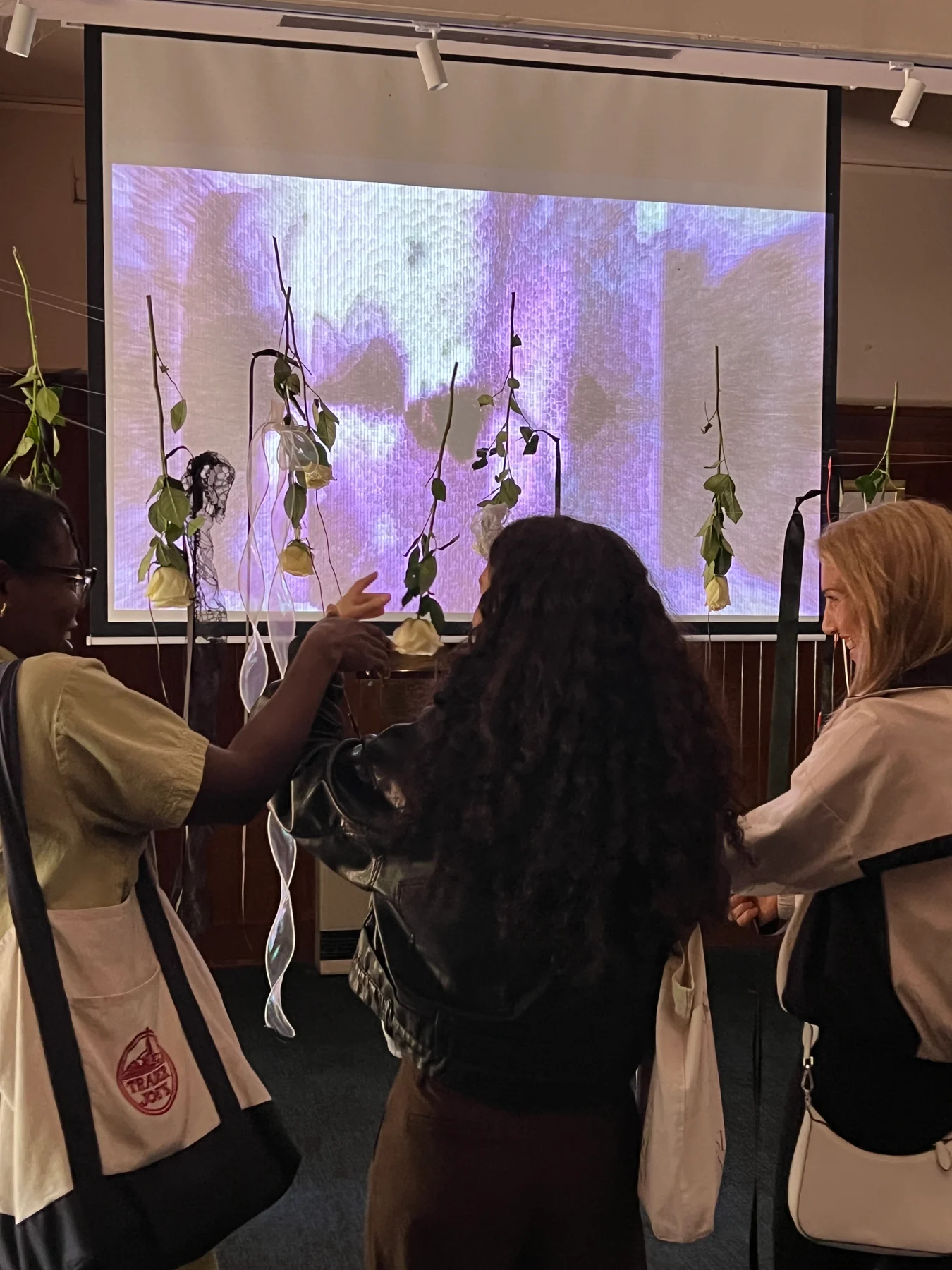 A participant touches the hanging-rose interface in Naming, Melbourne, October 2026.